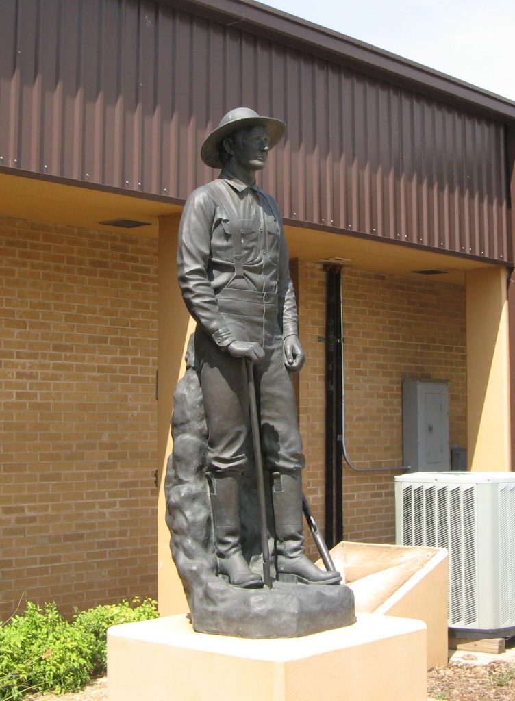 Bronze statue of a man in a wide-brimmed hat