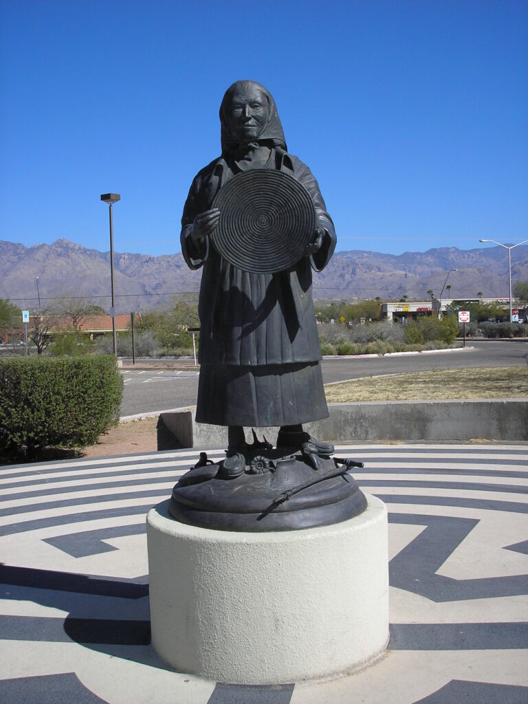 Bronze statue of a woman holding a basket